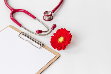 White gynecologist clipboard with red flower and stethoscope - obrazy, fototapety, plakaty
