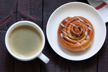 Cinnamon buns with icing served with coffee. Rustic style.