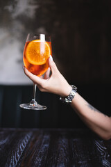 Orange cocktail with citrus and ice on a dark background