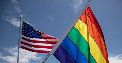 The United States flag waves along with the Pride rainbow flag at a rally in Florida
