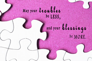 Motivational quote on white jigsaw with missing pieces on purple background.