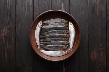Fresh sardines on rustic wooden background.
