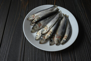 Fresh sardines on rustic wooden background.