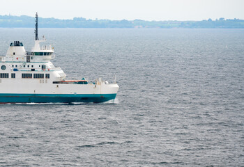 Fototapeta na wymiar A white passenger and car Ferry sailing at sea.