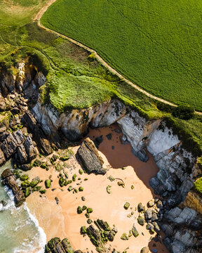 Aerial view of a small secret beach with white sand, Playa de Serantes, Tapia de Casariego, Asturias, Spain.