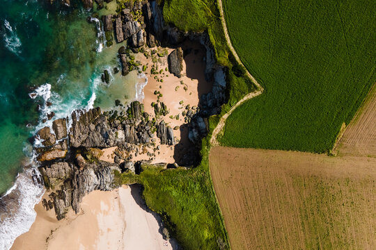 Aerial view of a small secret beach with white sand, Playa de Serantes, Tapia de Casariego, Asturias, Spain.