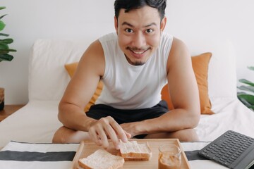 Happy asian man eat homemade sandwich and espresso coffee as breakfast.