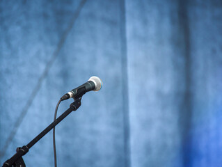 Auf einer Bühne steht ein während einer Pause ungenutztes Mikrofon.
