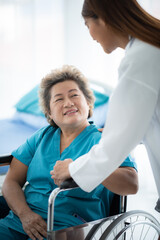 Obraz premium Smiling young female doctor checking and measuring blood pressure of senior patient