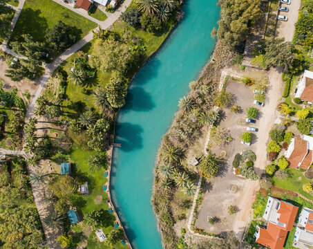 Aerial view of cultivated fields with hills in the background and Kibbutzim Stream, Nir David, Northern District, Israel.