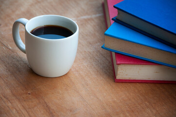 Coffee with books on wooden desk. Copy space.