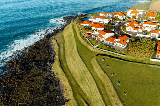 Aerial view of residential houses along the coast in Vila Franco do Compa and coastline, Sao Miguel, Azores, Portugal.