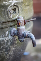 An einem alten Bierfass ist ein Ablasshan angebracht.
