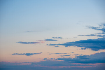 Abstract orange gold sunset sky background with motion blur. Natural sky background to replace the sky in your photos. Dark blue evening sky with clouds. Gold hour.