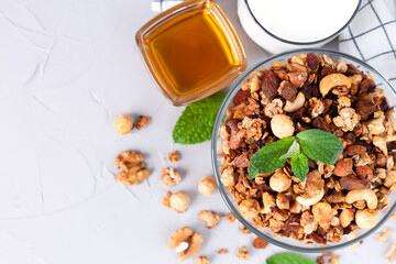 Homemade granola with nuts, yogurt and honey for breakfast. Healthy food concept. Сlose-up. Place for text. Top view.