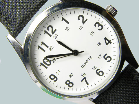 Watch from above. A fashionable, trendy, stylish and high end mens wristwatch. Closeup watch face in studio isolated against a grey background. Set your alarm, be early or on time and never late