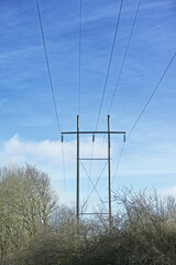 Power lines against clear blue sky background with copyspace. Industrial energy line, shut down for...