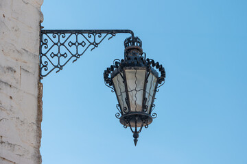 Fototapeta na wymiar Old and vintage design street lamp bulb with blue sky background. Building illumination. Retro lantern lighting