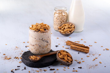 Overnight oats with Granola. Accompanied with almonds and a spoon of oats. Cloves and cinnamon...