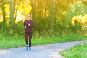 Fototapeta premium Beautiful smiling girl runs through the morning forest.