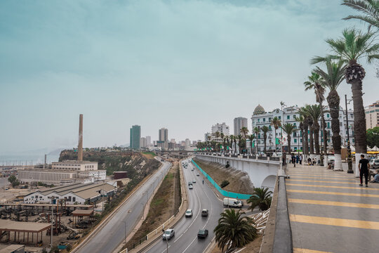 View from the Oran beachfront avenue towards palms, road and hotels in the background. Beautiful Cityscape of Oran, Algeria on a sunny day.