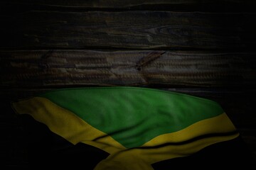 wonderful national holiday flag 3d illustration. - dark image of Jamaica flag with large folds on old wood with free space for your content