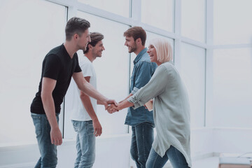 colleagues shaking hands in the office lobby