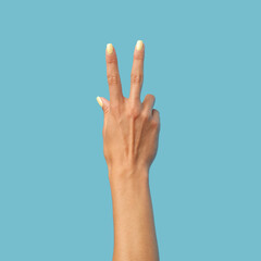 Female hand on a blue background in various positions.