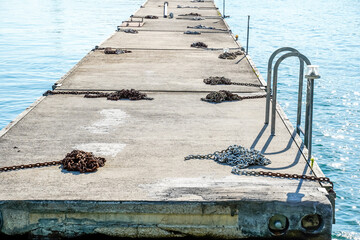 Floating dock on the lakeside of Chicago. Michigan Lake. Many chains are placed on the cement dock.