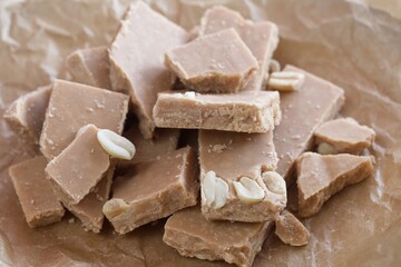 Iris creamy. Homemade candy. In craft paper. On pine boards. Close-up.