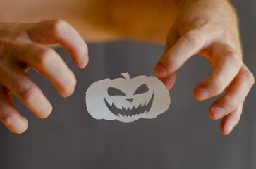 White Paper Halloween Pumpkin and hands with fingers bent in terror. Halloween paraphernalia cut...