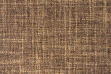 Close-up texture of natural brown coarse weave fabric or cloth. Fabric texture of natural cotton or linen textile material. Blue canvas background. Decorative fabric for upholstery, furniture, walls