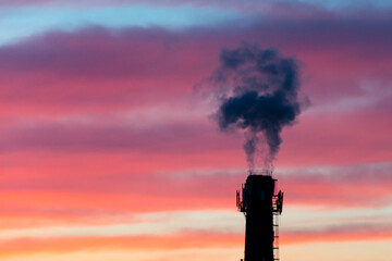 Factory smoking pipe, emissions of smoke into the atmosphere of the city. Evening sky