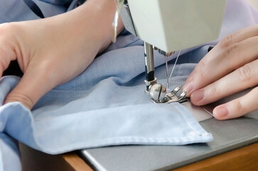 Obraz na płótnie Canvas Sewing striped shirt on a sewing machine. Сlose up