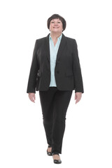 Mature business woman in a pantsuit striding forward.