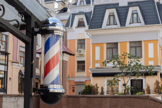 A barber's pole sign used by barbers to signify the place or shop where they perform their craft. City view