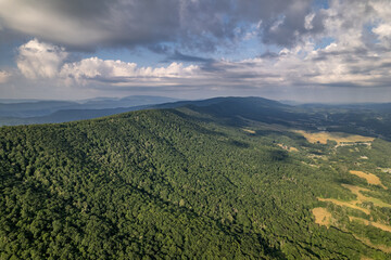 Green Mountains and Farmland under Dramatic Clouds