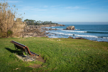 A wooden bench on the coast facing out to sea, Noja, Cantabria, Spain