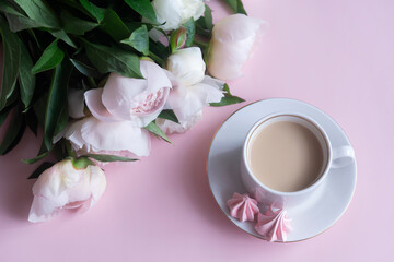 Fototapeta na wymiar Cup of coffee and white peonies on a wooden background. Top view, copy space.