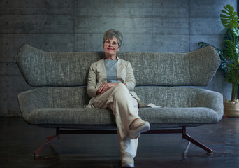 Smiling middle aged mature grey haired woman looking at camera, happy old lady in glasses posing at home indoor