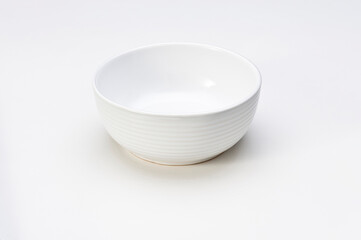 Simple empty ceramic white bowl with grooved lines, isolated on white
