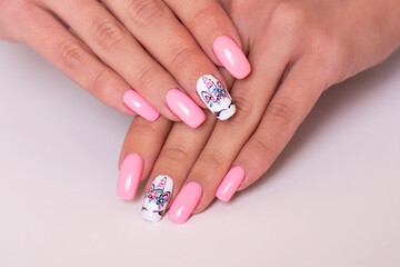 Beautiful female hands with creative manicure nails with unicorn design, pink gel polish
