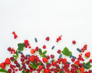 Different kind of berries on white background.  Strawberries honeysuckle raspberries cherries and red currants on white background.