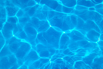 Sunlight creating abstract design on swimming pool water 