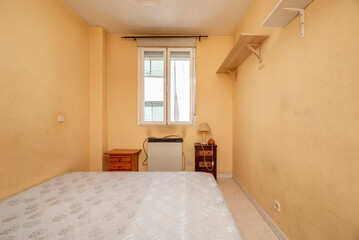 Bedroom with sofa, white aluminum window, wooden nightstands and disparate shelves on the wall
