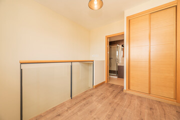Bedroom in a two-story loft with stairs, chestnut wood flooring and built-in wardrobes with sliding doors