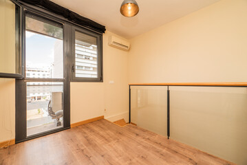 Two-storey loft apartment with stairs, terrace and glass partition with light brown wooden floors