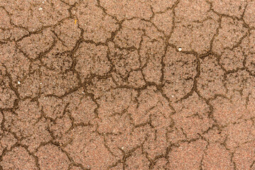 Cement background of reddish color with cracks, roughness and textures.