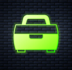 Obraz premium Glowing neon Case or box container for wobbler and gear fishing equipment icon isolated on brick wall background. Fishing tackle. Vector