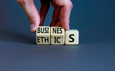 Business ethics symbol. Concept words Business ethics on wooden blocks. Businessman hand change...